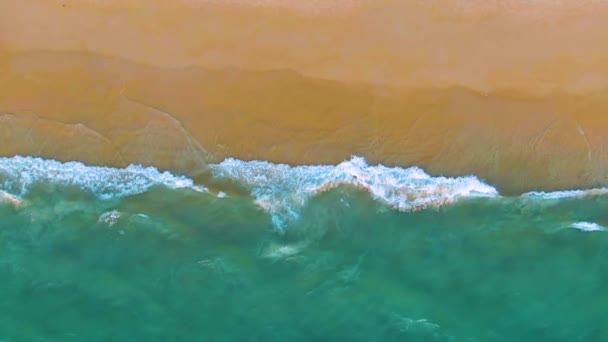 Vista superior de una playa de arena tropical. Ondas oceánicas en cámara lenta. Vista aérea 4k — Vídeo de stock