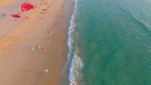 Sonnenuntergang am Strand von Karon, Menschen schwimmen im Meer und sonnen sich am Strand des Resorts. Ein paar Tage vor der Schließung der Strände aufgrund der Quarantäne covid-19. Luftaufnahmen in 4k — Stockvideo