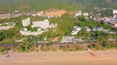 Hava 4k manzarası tropikal mavi okyanusun üzerinden güzel yeşil dağlara ve beyaz kumlu plaja doğru uçuyor. Tayland. Phuket. Karon plajı. Palms plajı. Ada manzaralı. Güzel tatil yeri.