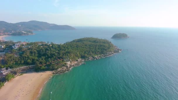 Flygfoto 4k utsikt flyger över tropiskt blått hav mot vackra gröna berg och vit sandstrand. Thailand. Det är Phuket. Stranden Karon. Palmstranden. Öns ovanifrån. Vacker semesterort. — Stockvideo