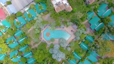 Grand Hyatt Kauai Lüks Otel Tatil Köyü. İHA 'yla havadan 4k' lik görüntü. Palmiye ağaçları, güneşlik, şemsiye, jakuzi. Su kaydırağı Havuzlar, bahçe, kıyı şeridi ve plaj yukarıdan.