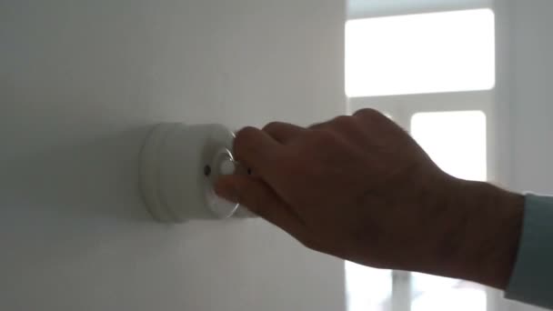 Une main d'homme allume et éteint un interrupteur dans une maison — Video