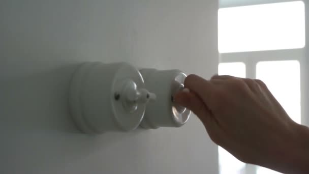 Uma mão mulher ligando e desligando um interruptor de luz em uma casa — Vídeo de Stock