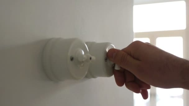 Een man hand draaien aan en uit een lichtschakelaar in een huis — Stockvideo