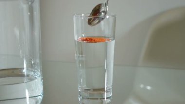 Bir kaşığı kırmızı biber tozu su ile cam ekledi ve karışık