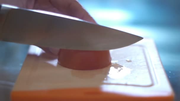 Hand cutting tomato in a kitchen — Stock Video
