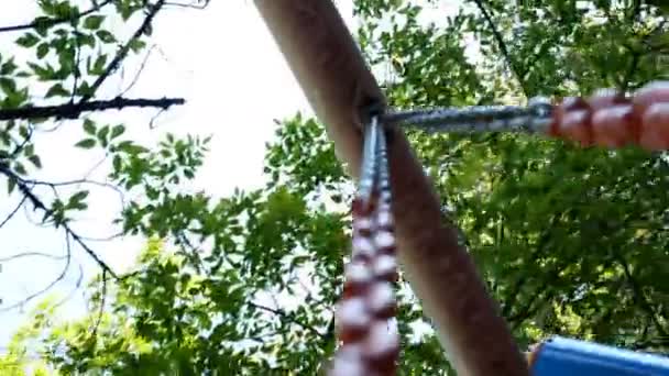 Montar en un balancín de niños con una vista del cielo — Vídeo de stock