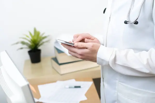 A female doctor texting on smartphone — Stock Photo, Image