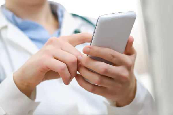 Une femme médecin textos sur smartphone — Photo