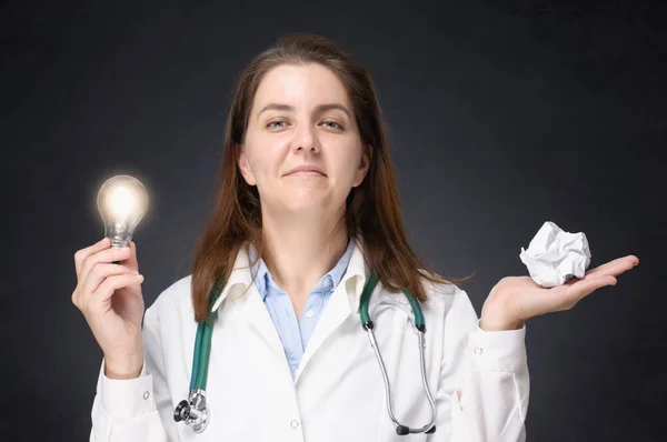 Läkare med glödande glödlampa och skrynkligt papper — Stockfoto