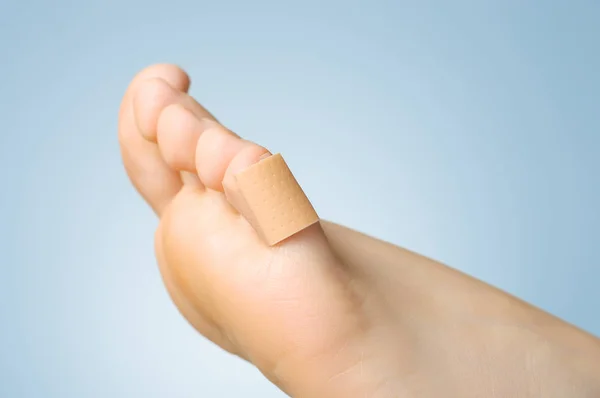Fechar-se de um bandaid em dedo do pé feminino — Fotografia de Stock