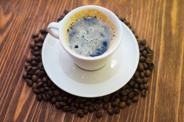 Beyaz fincan kahve taneleri ile