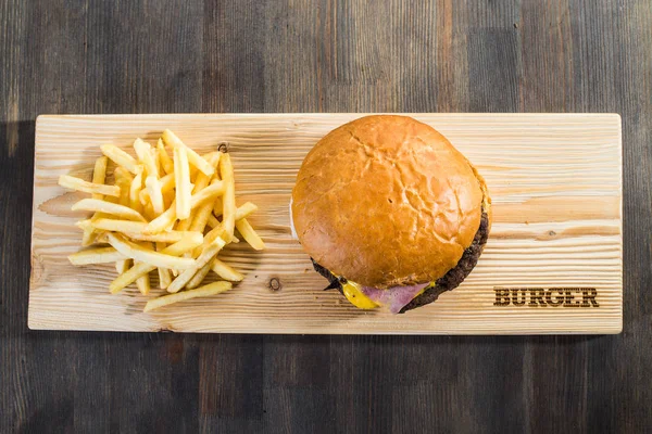 Basteln eines Burgers auf dem Brett mit Pommes — Stockfoto