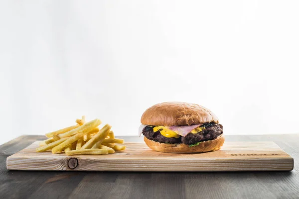 Knutselen van een hamburger op het bord met frietjes — Stockfoto