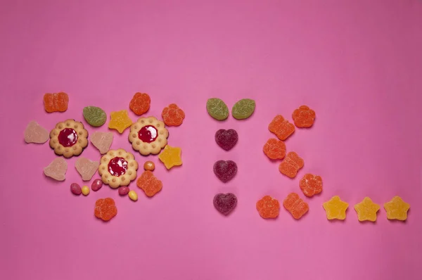 valentine's love is food art made of marmalade and cookies on pink background