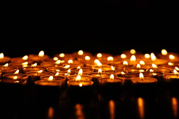 Muchas velas. Quemando velas en la oscuridad. Velas amarillas . —  Fotos de Stock