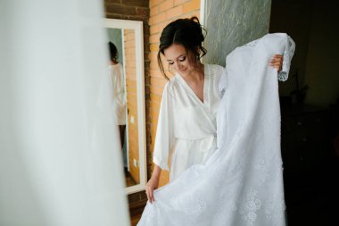 Düğün günü. Güzel mutlu gelin lüks gelinlik inceliyor. Gelin düğün günü sabah.