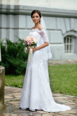 Düğün. Bir gelinlikle çok güzel bir gelin portresi ile bir buket çiçek düğün üzerinde.