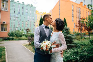 Damat ve gelin düğün renkli Bina zemin üzerine, öpüşme