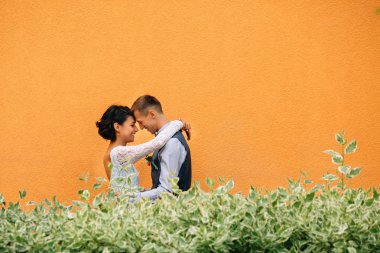 Düğün günü. Mutlu gelin ve damat her diğer kopya alanı sarı duvar zemin üzerine sarılma