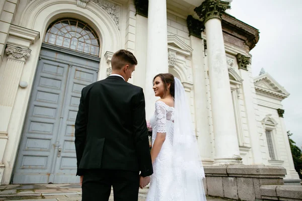 Boda. Novia y novio tomados de la mano y subiendo las escaleras del castillo. Día de la boda . — Foto de Stock