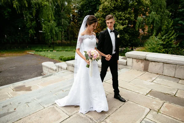 Día de la boda. Amándose unos a otros recién casados caminando después de la ceremonia de boda . — Foto de Stock