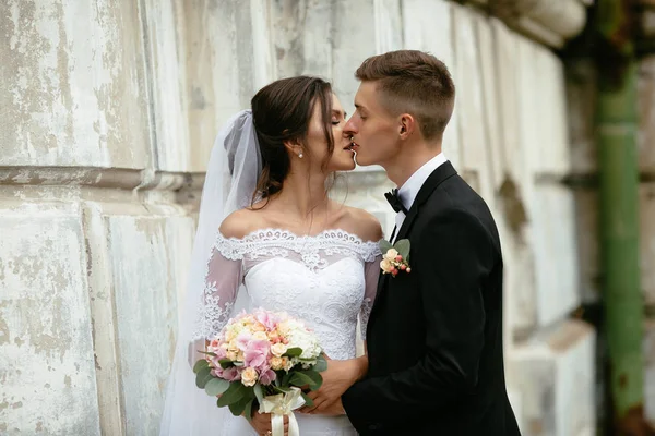 Feliz novia y novio besándose en el día de su boda . — Foto de Stock