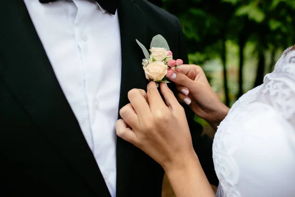 결혼식. 신부는 그들의 결혼식에서 신랑 boutonniere을 수정합니다. 클로즈업 세부 정보. — 스톡 사진