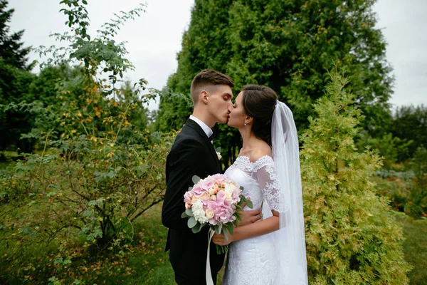 Boda. Encantadora novia y novio besándose en el día de su boda . — Foto de Stock