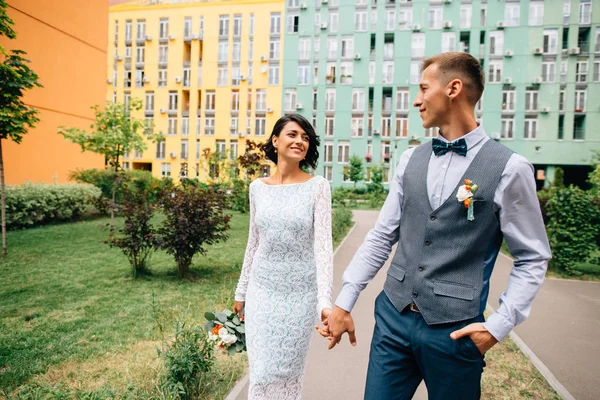 Novia y novio caminando por la calle urbana con edificios coloridos —  Fotos de Stock