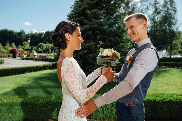 Glad brudgummen ger bruden bukett av bröllop blommor — Stockfoto
