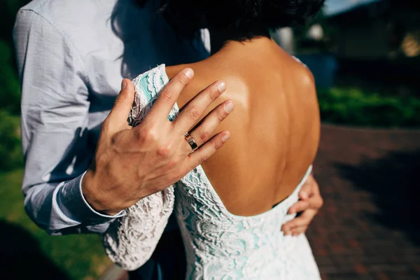Mano del novio con anillo de boda abrazando hombro de novia — Foto de Stock