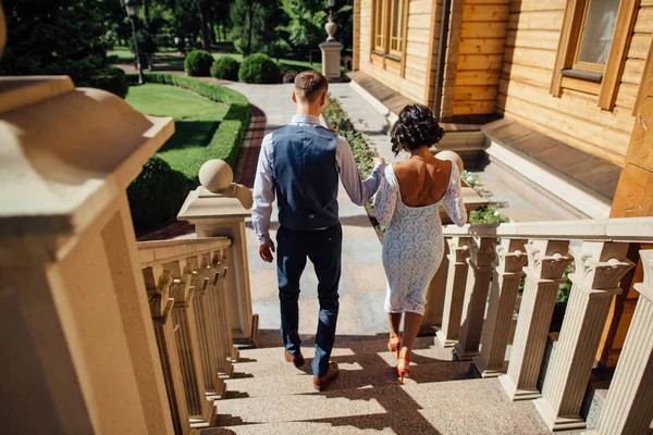 Les jeunes mariés descendent les escaliers du manoir de luxe le jour du mariage — Photo