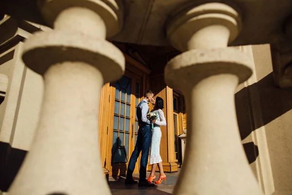 Heureux jeunes mariés embrassant sur le porche de la maison — Photo