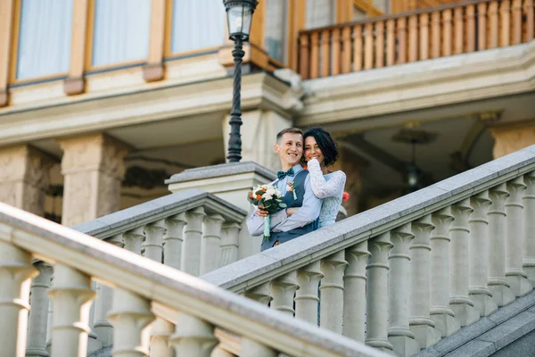 Mariée heureuse et marié étreignant sur les escaliers du manoir — Photo