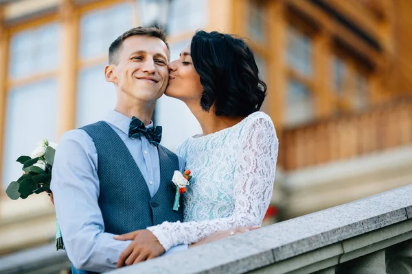 Novia besando novio feliz en la mejilla en el día de la boda — Foto de Stock