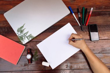 İşyeri, beyaz kağıda el çiziyor. El ile renk kalemler ahşap arka plan - boş bir kağıda kadar sahte çizimi