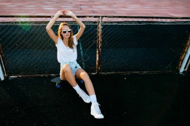 Selfie kız bir kuruş kaykay üzerinde oturuyor iken üç arkadaş