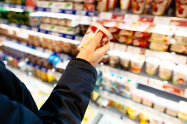 Süpermarket alışveriş. Adam süpermarket yoğurt raf ömrünü kontrol edin. Bulanık fotoğraf