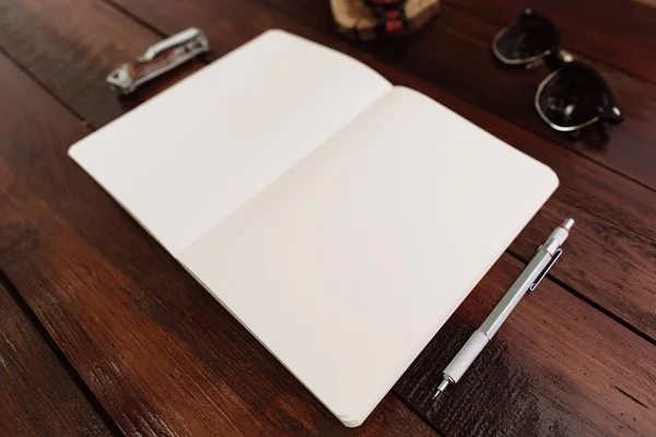 Cuaderno abierto con bolígrafo, relojes de pulsera, gafas de sol y cuchillo — Foto de Stock