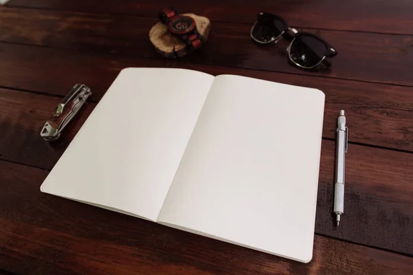 Cuaderno abierto con bolígrafo, relojes de pulsera, gafas de sol y cuchillo — Foto de Stock