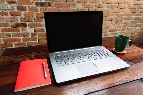 Miejscu pracy, laptop, czerwony notebook z pióra i filiżankę kawy na drewniany pulpit i tło Cegła - makiety — Zdjęcie stockowe