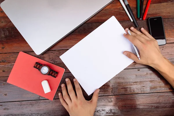 Lugar de trabajo, la mano está dibujando en la hoja blanca. Dibujo a mano sobre una hoja de papel en blanco con lápices de color sobre un escritorio de madera. — Foto de Stock