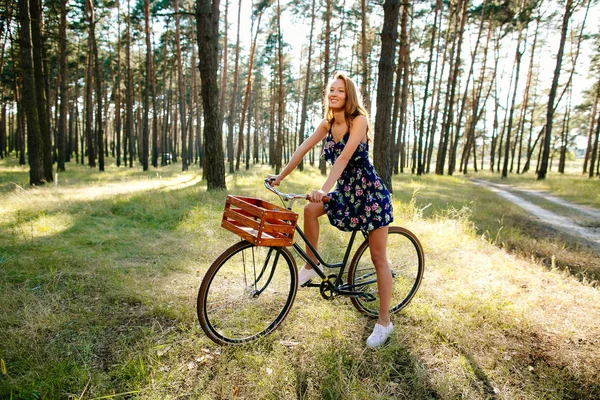 森の中で自転車に乗って幸せな女の子. — ストック写真
