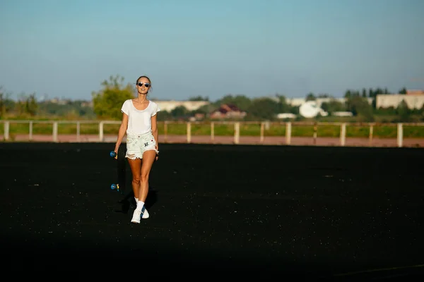 Caminante chica con un monopatín . — Foto de Stock