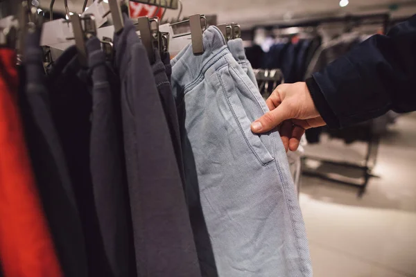紳士服店でのショッピング。男は、衣料品店で服を選択します。ショッピング概念 — ストック写真