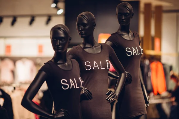 女性衣料品店での販売。婦人服店で「特売」をした黒い T シャツのマネキン3つ。販売コンセプト — ストック写真