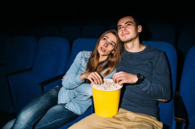  Sinema tarihi, romantik film sinemada izlerken patlamış mısır ile mutlu genç Çift.