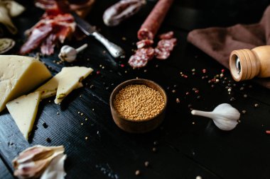 Hardal çekirdekleri ile tütsülenmiş sosis, peynir, sarımsak ve biber değirmeni 