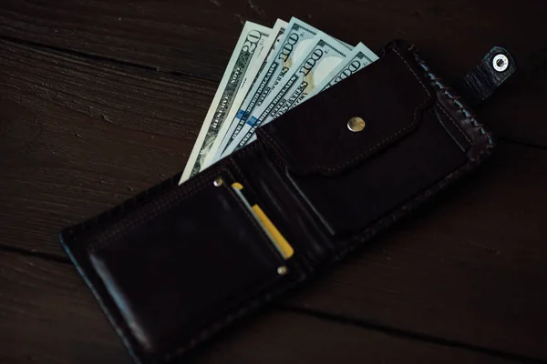 Wallet with dollars cash. Open wallet with dollars banknotes and credit cards on wooden background